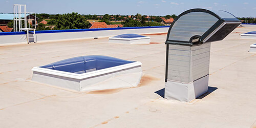 Roof of a commercial building with skylights and exhaust vents.